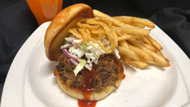 Pulled Pork Sandwich, topped with coleslaw and served with french fries