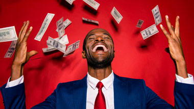 man in suit with money raining down on him