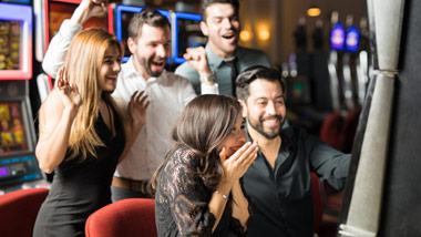 young friends celebrating a win at the slot machine